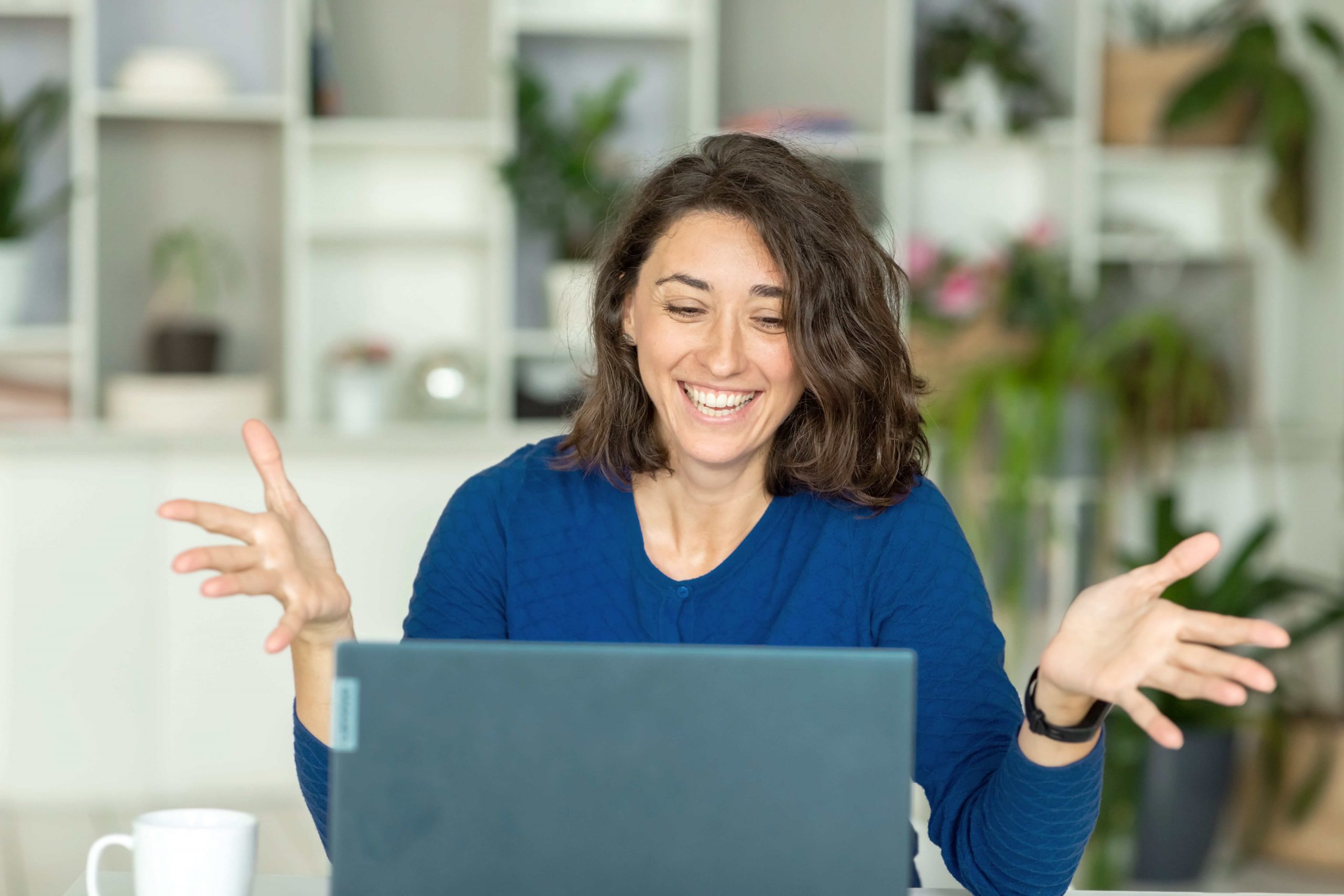 happy-brunette-woman-uses-laptop